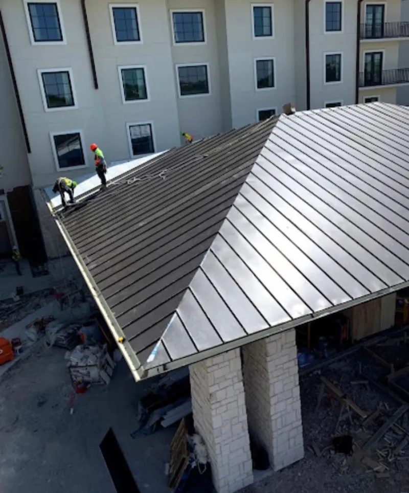 Crew installing standing seam metal roof panels on a commercial project in Beverly Hills